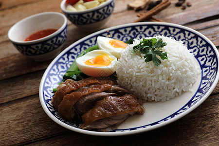 当地泰国食品在木本背景中孤立的米饭上煮猪肉腿文化食物盘子美食街道午餐图片