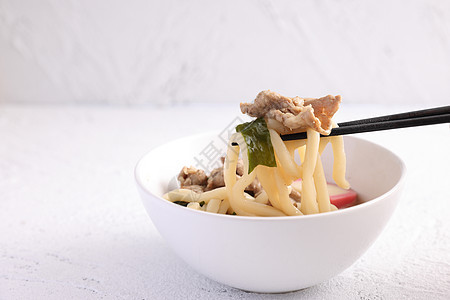 白背景的乌东面面条与猪肉分离大豆烹饪蔬菜小麦午餐盘子传统洋葱拉面食物图片