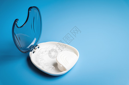 正畸护理 在 3d 打印机上打印的新型隐形塑料对准器位于一个特殊的白色盒子中 在蓝色背景中没有人牙套玩具牙医牙齿宏观压缩牙科工作图片