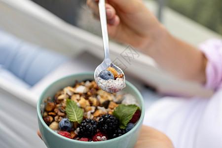 吃薯布丁加果子和浆果勺子酸奶营养种子水果坚果饮食小吃图片