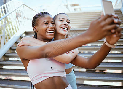 在城市锻炼期间 通过电话锻炼 交朋友和自拍 与快乐 放松的女性结合并大笑 社交媒体 内容创作者和女孩在跑步后在博客上摆姿势进行在图片