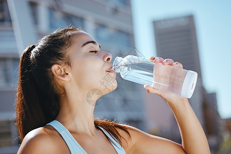 在户外夏季有氧运动训练中放松 健身和喝水的女孩 口渴的运动女性享受从瓶子到水合物身体的水饮料 以实现健康的生活方式图片