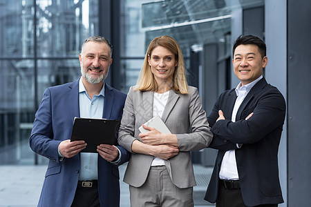 成功的梦之队 多元化的亚洲男人和女商务人士微笑着看着镜头 办公楼外双臂交叉的同事 专业投资者和银行家折叠联盟办公室职员成人女性工图片