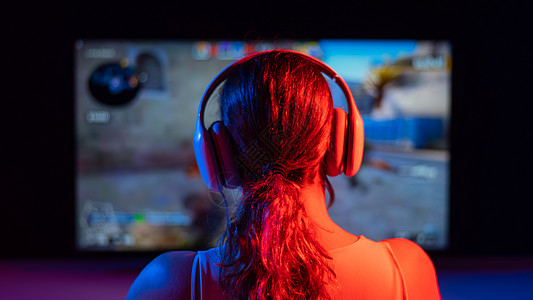 一名白人女性在黑暗中在霓虹灯下玩电脑游戏的后视图电脑喜悦屏幕竞赛麦克风女孩玩家电子游戏老鼠锦标赛图片