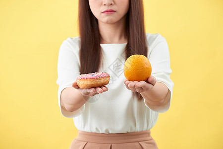 女人拿着橙和甜甜圈蛋糕甜点橙子身体女性食物水果营养女孩女士图片