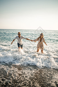 幸福的情侣在海边 蜜月爱好者 岛上的男人和女人 美丽的夫妇在海边玩 幸福的夫妇在度假 海边的男人和女人海浪旅行海岸晴天投标女士横图片