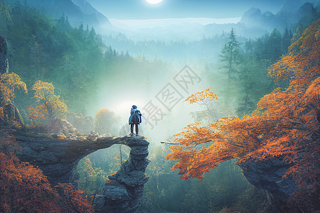 无畏的旅行者站在悬崖上 俯视秋天的森林和高雅的浅蓝山脉太阳公园游客地标顶峰冒险背包日落旅行活动图片