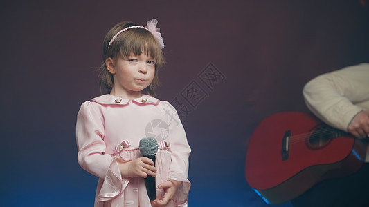 穿着粉红旧裙子的可爱小女孩 站在舞台上有麦克风嗓音宝宝才俊青年戏服轻音乐乡村舞蹈爸爸衣服图片