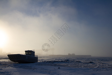 登陆船中心控制台 铝动力艇 坐落在雪覆盖海滩的雪上低潮冒险血管风暴苔原铝船白色中控台摩托艇土地图片