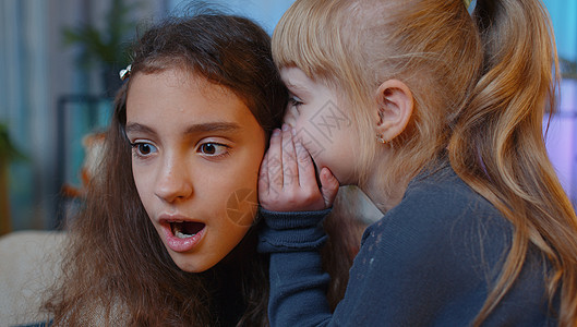 幼童低语传来的新闻谣言 在小妹妹的耳边 孩子女孩分享秘密 闲聊玩乐故事女性谈判智慧女朋友朋友们青春期沙发孩子们童年图片