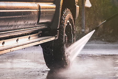越野驾驶后 用高压水式喷水机在自助洗车时清洗公路车辆图片