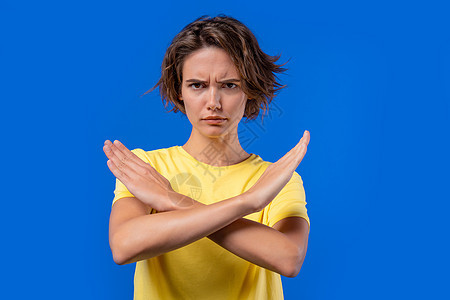 不感兴趣的女人不赞成没有交叉手势 否认 拒绝 不同意 蓝色背景的年轻女士画像 超时概念图片