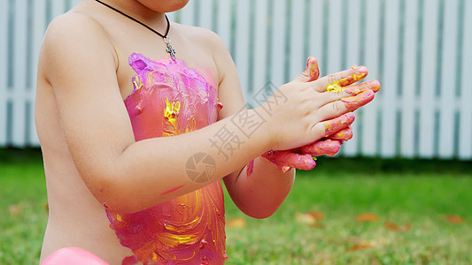 一个小孩 一个四岁的男孩在玩耍 用手指画画 装饰自己 在花园里 坐在毯子上 在草地上 草坪上 在夏天 他很开心游戏教育男生绿色画图片