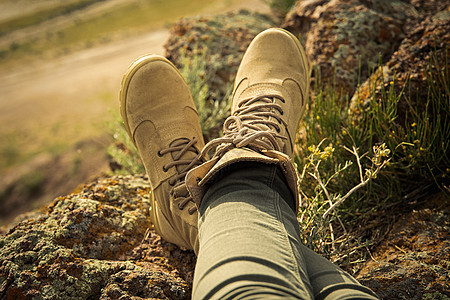 穿着高带高的徒步鞋 在岩石地形旅行风格中的女性双腿上图片