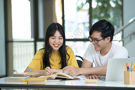 年轻学生校园帮助朋友追赶和学习 并帮助他们学习团体会议笔记考试图书青少年知识大学课堂演讲图片