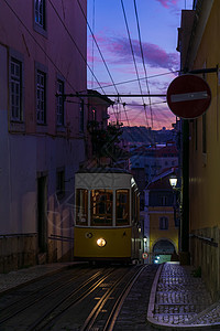 日落时 古老的黄色有线车在狭窄的葡萄牙街道上图片
