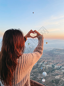 在土耳其卡帕多西亚观看热气球的日出快乐妇女旅行航班旅游悬崖自由胡同娱乐岩石飞机游客图片