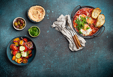 中东早餐或早午餐 与Shakshouka 吐司 蔬菜沙拉 hummus 橄榄复制空间香菜盘子乡村美食餐厅平底锅食物面包鹰嘴菜单图片