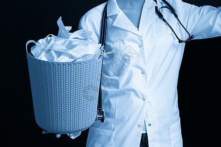 医生用桶装满了旧面罩 扔掉作为流行病结束的象征物病痛卫生面具治疗保健安全感染流感蓝色医院图片