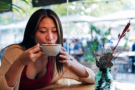 在咖啡店喝咖啡的年轻年青女子背景图片
