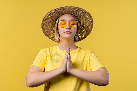 可爱的女人祈祷 乞求向她道歉 她有罪 黄色背景 充满希望的祈祷女孩要求有人满足她的欲望 帮助图片