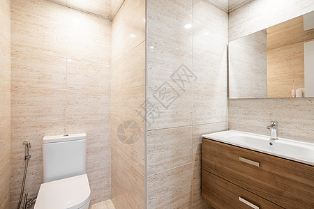 现代宽敞的厕所内有白色马桶浴盆和木制家具 )图片