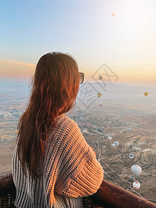 在日出时快乐的女人 观看热气球秀 从在土耳其卡帕多西亚的天上的篮子上展示图片