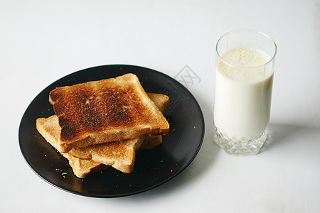 桌上有玻璃牛奶和烤面包瓶子早餐盘子营养背景图片