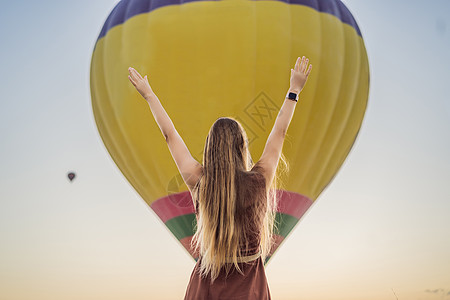 在土耳其卡帕多细亚看热气球的女游客 土耳其概念中的快乐旅行 山顶上的女人享受美妙的景色空气航班自由国家旅游天空冒险气球女孩日出图片