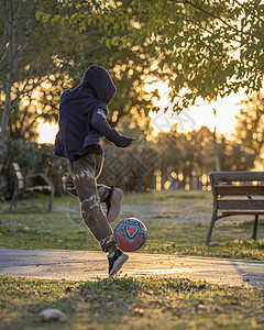 年轻的天主教男孩在自然界日落时 练习足球技巧和花招 玩足球游戏的天性图片