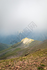 神秘而微小的极高海拔地貌似山岳风景 云层触动了大山峰和一座山上的光点图片