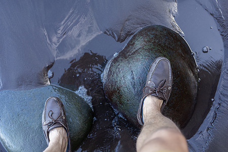 雄脚在水面上的绿色石頭上运动鞋类海岸靴子冒险黑色平衡活动男人远足图片