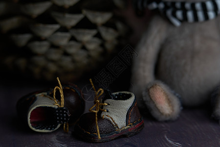 泰迪熊脚边的皮小鞋 为小脚儿童和他们的父母制造时尚时尚鞋的轻工业概念高跟鞋玩具织物手工娃娃女性婴儿娃娃鞋靴子鞋类图片
