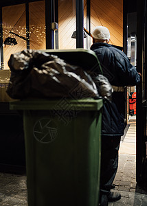 工人拿一个装满绿色垃圾箱的垃圾垃圾 从圣诞节酒吧回收 (笑声)图片