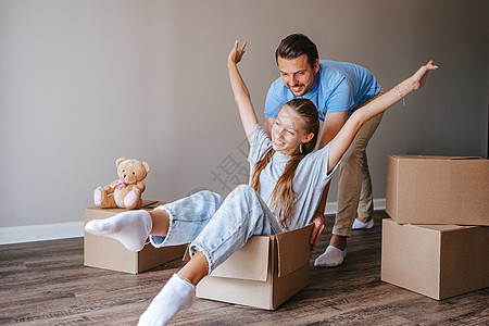 父亲和可爱的少女女儿的家人 在新家搬家时玩得开心点生活父母玩具熊女孩开箱男人家庭房子公寓成人图片