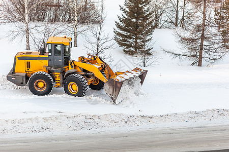 雪后初霁清理雪地 拖拉机在大雪降雪后扫清了道路司机挖掘机雪堆人行道运输车辆打扫服务暴风雪行动背景