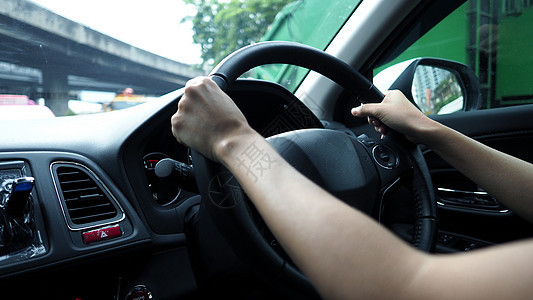 女性满怀信心地驾驶汽车的近身形象车轮司机城市控制气体男性技术交通旅行速度图片