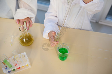 选择性焦点 孩子们在化学课上使用刻度吸管 烧杯 试管进行化学实验图片