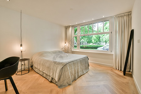 带有床和大窗户的卧室建筑学酒店地毯风格房子奢华枕头休息沙发住宅图片