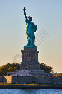 纽约市自由女神像在金光下闪光照亮的灯光中图片