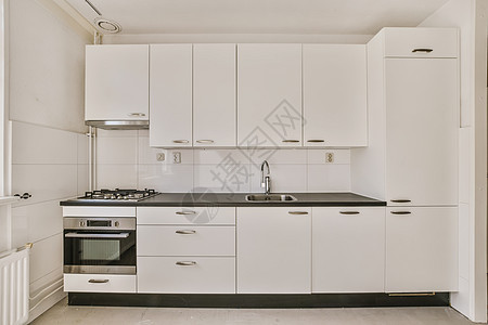厨房 有白色的柜子 炉灶和水槽烹饪橱柜住宅器具奢华烤箱房间龙头柜台桌子图片