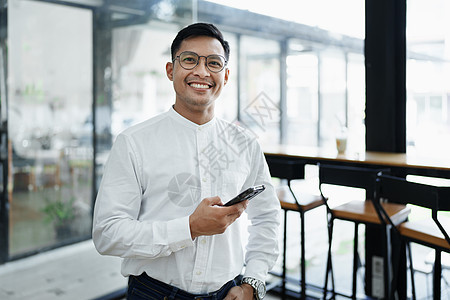 企业业主或亚洲男性销售商在办公室工作时使用商业电话和摄影互联网成人职业水平技术电脑文档人士笔记本图片