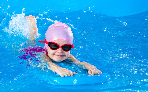 学龄前可爱的小女孩 学会在室内游泳池里游泳漂浮泡沫运动孩子游泳者浮板训练风镜水池乐趣图片