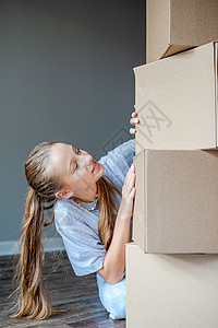 快乐的女孩搬进新房子 带纸板盒公寓房间女士运输女性学生开箱纸盒房地产地面图片