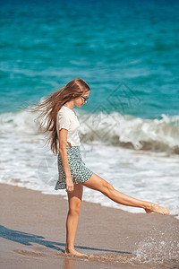 在热带海滩的浅水度假期间 适客少女在热带海滩玩得开心女性童年海浪旅游自由异国假期情调支撑海滨图片