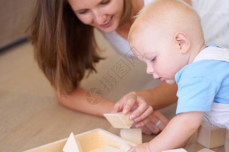和妈妈一起度过好时光 一个年轻母亲和她儿子一起玩建筑砖块游戏的小孩儿图片