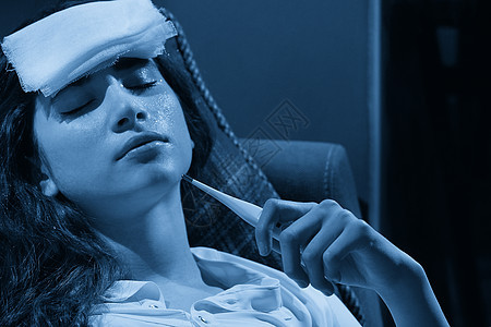 在沙发上拿着温度计的年轻女性发烧 被抓 有流感症状 流感或病毒概念的生病女孩疾病头痛喷嚏客厅女士感染成人蓝色疼痛温度图片