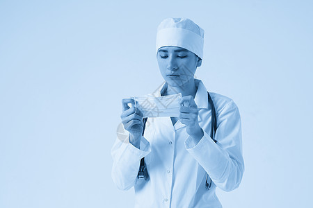 年轻女医生在白色背景 复制空间上戴上保护性医疗面罩的肖像 以职业蓝色诊所手术面具护士药品医院调子流感图片