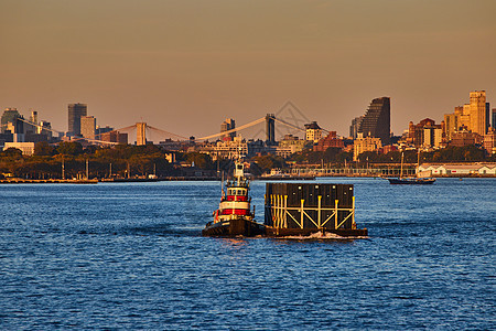 小型工业船在纽约工业黄金时段从侧面拉动集装箱图片