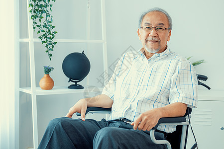 坐在轮椅上的老人的肖像 在家里满足和独自一人器材椅子照顾者男人老化成人护理残障人士退休图片